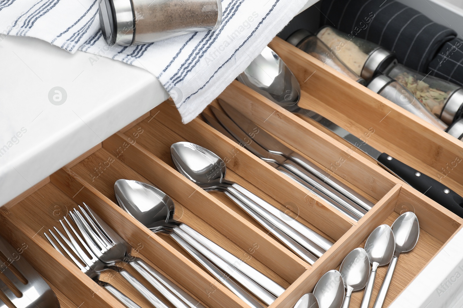 Photo of Box with cutlery in drawer, closeup. Kitchen utensils storage