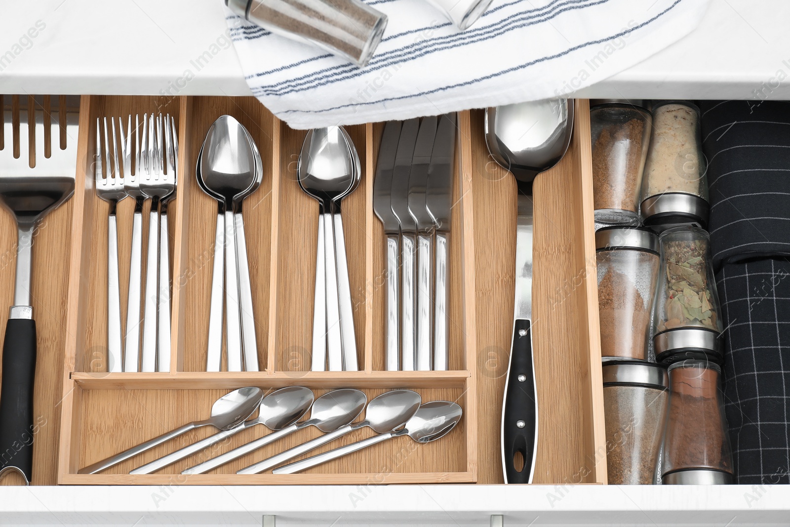 Photo of Box with cutlery in drawer, closeup. Kitchen utensils storage