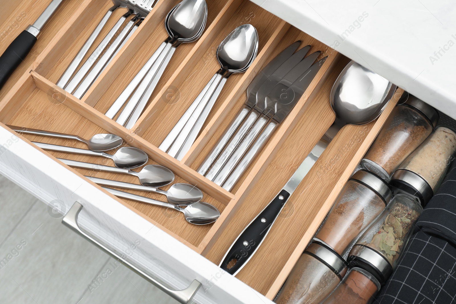 Photo of Box with cutlery in drawer, closeup. Kitchen utensils storage