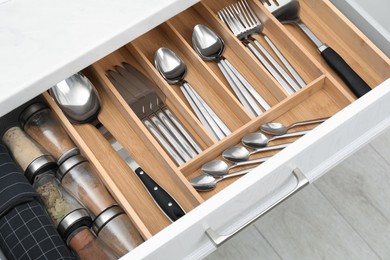 Photo of Box with cutlery in drawer, closeup. Kitchen utensils storage