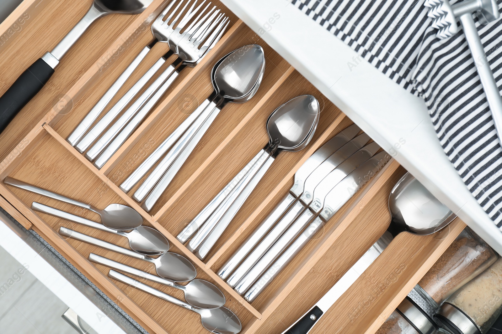 Photo of Box with cutlery in drawer, closeup. Kitchen utensils storage