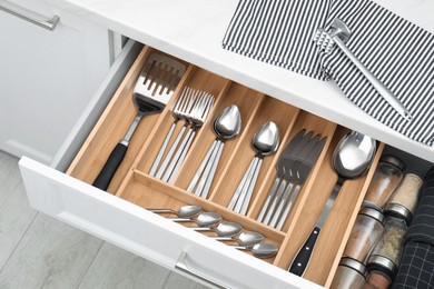 Photo of Box with cutlery in drawer, closeup. Kitchen utensils storage