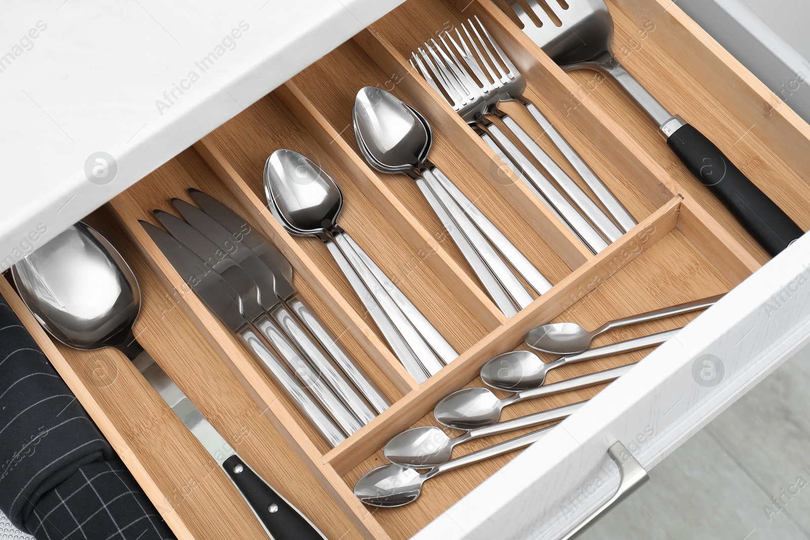 Photo of Box with cutlery in drawer, closeup. Kitchen utensils storage