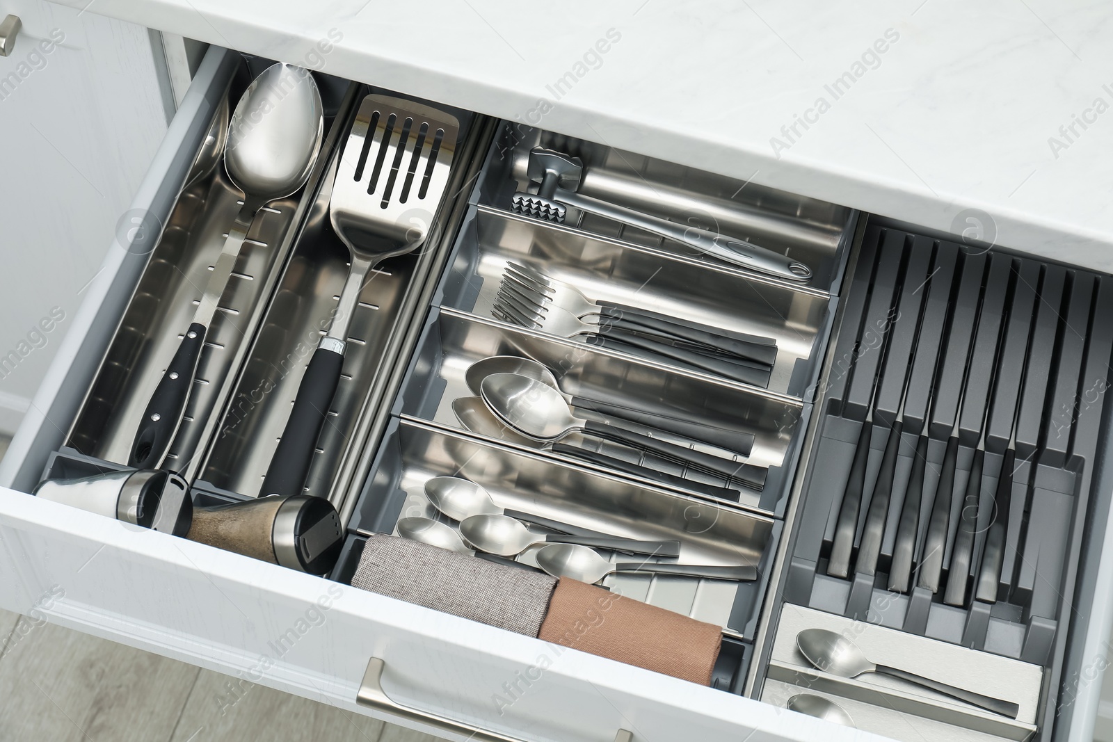 Photo of Box with cutlery in drawer, closeup. Kitchen utensils storage