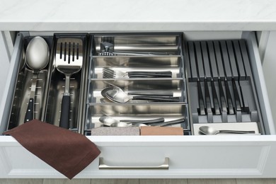 Photo of Box with cutlery in drawer, closeup. Kitchen utensils storage