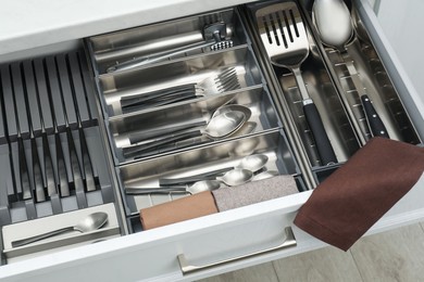 Photo of Box with cutlery in drawer, closeup. Kitchen utensils storage