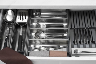 Photo of Box with cutlery in drawer, closeup. Kitchen utensils storage