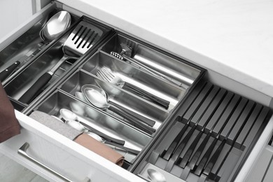 Photo of Box with cutlery in drawer, closeup. Kitchen utensils storage