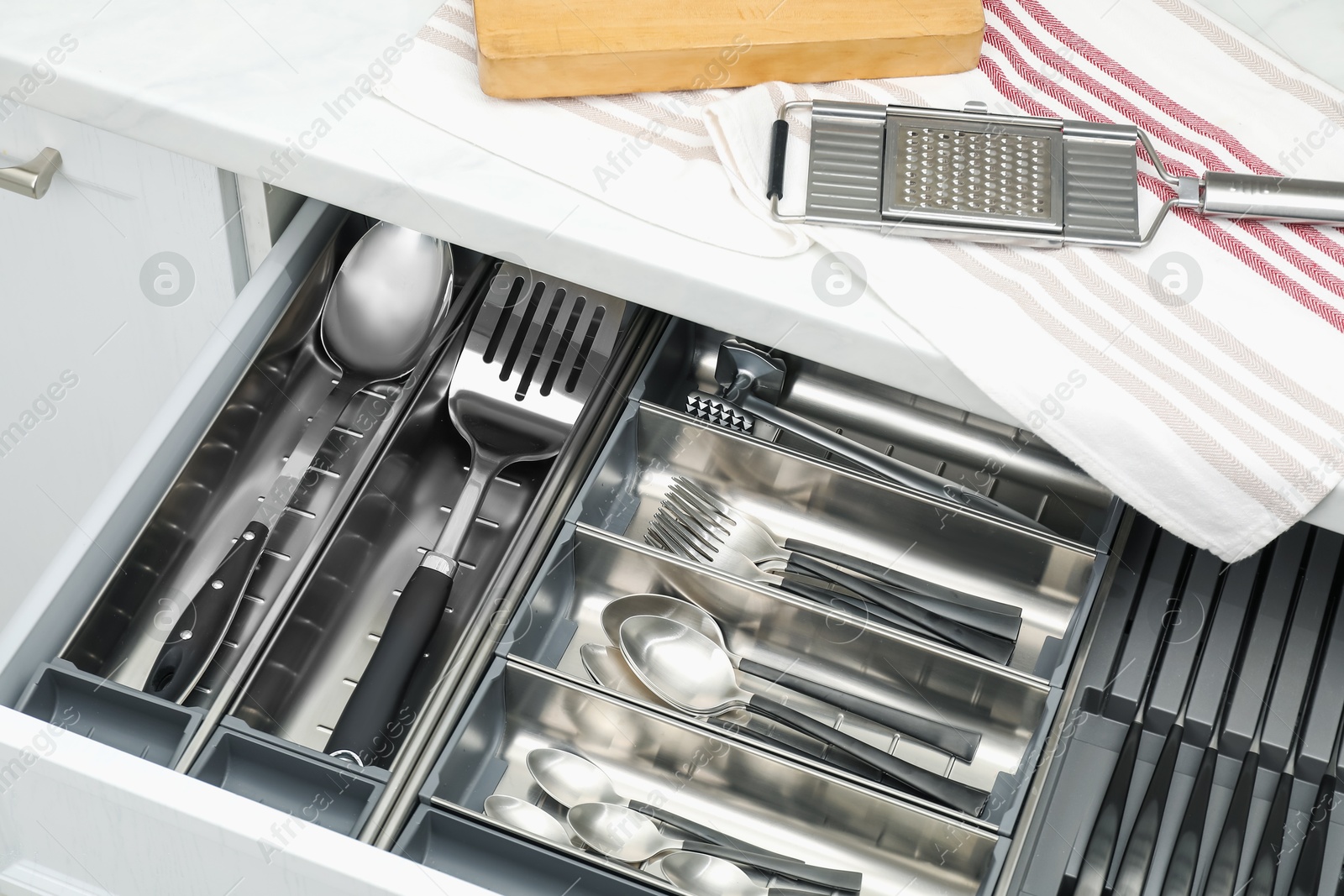 Photo of Box with cutlery in drawer, closeup. Kitchen utensils storage