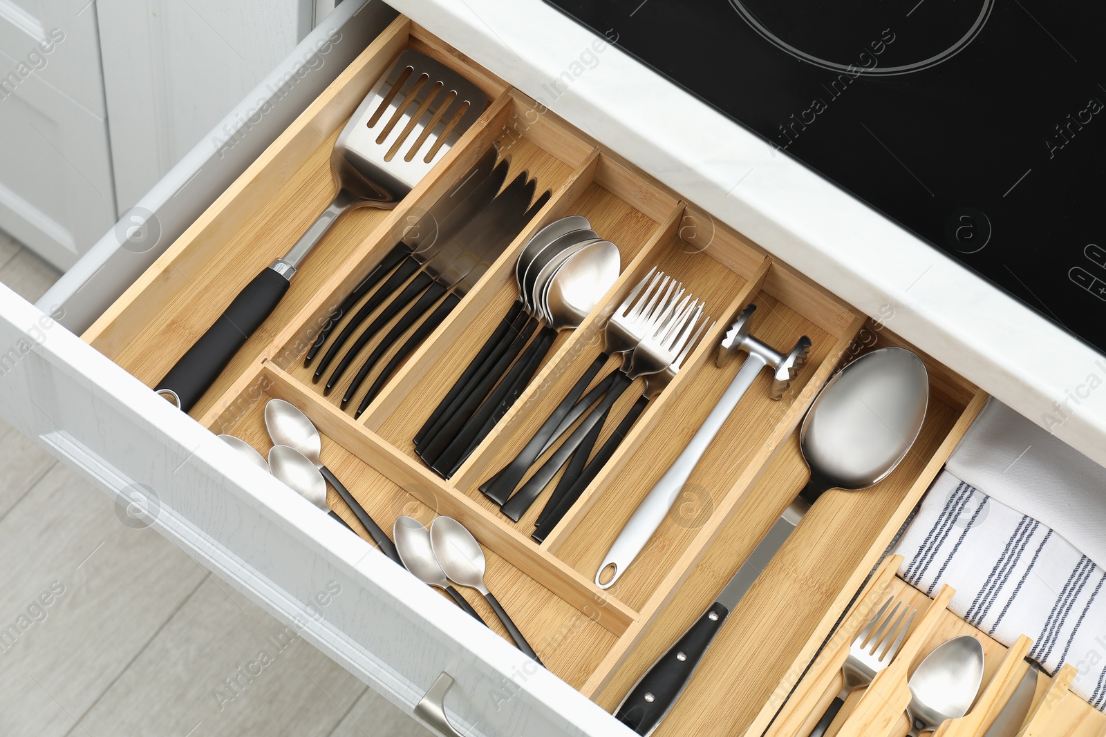 Photo of Box with cutlery in drawer, closeup. Kitchen utensils storage