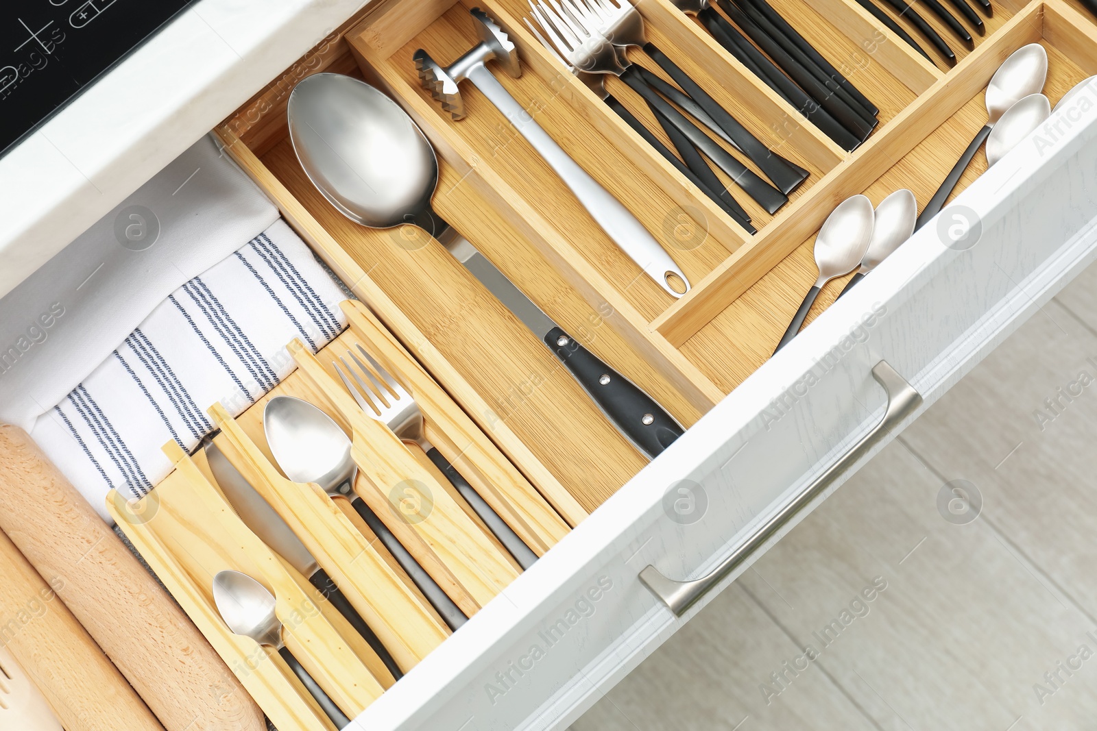 Photo of Box with cutlery in drawer, closeup. Kitchen utensils storage