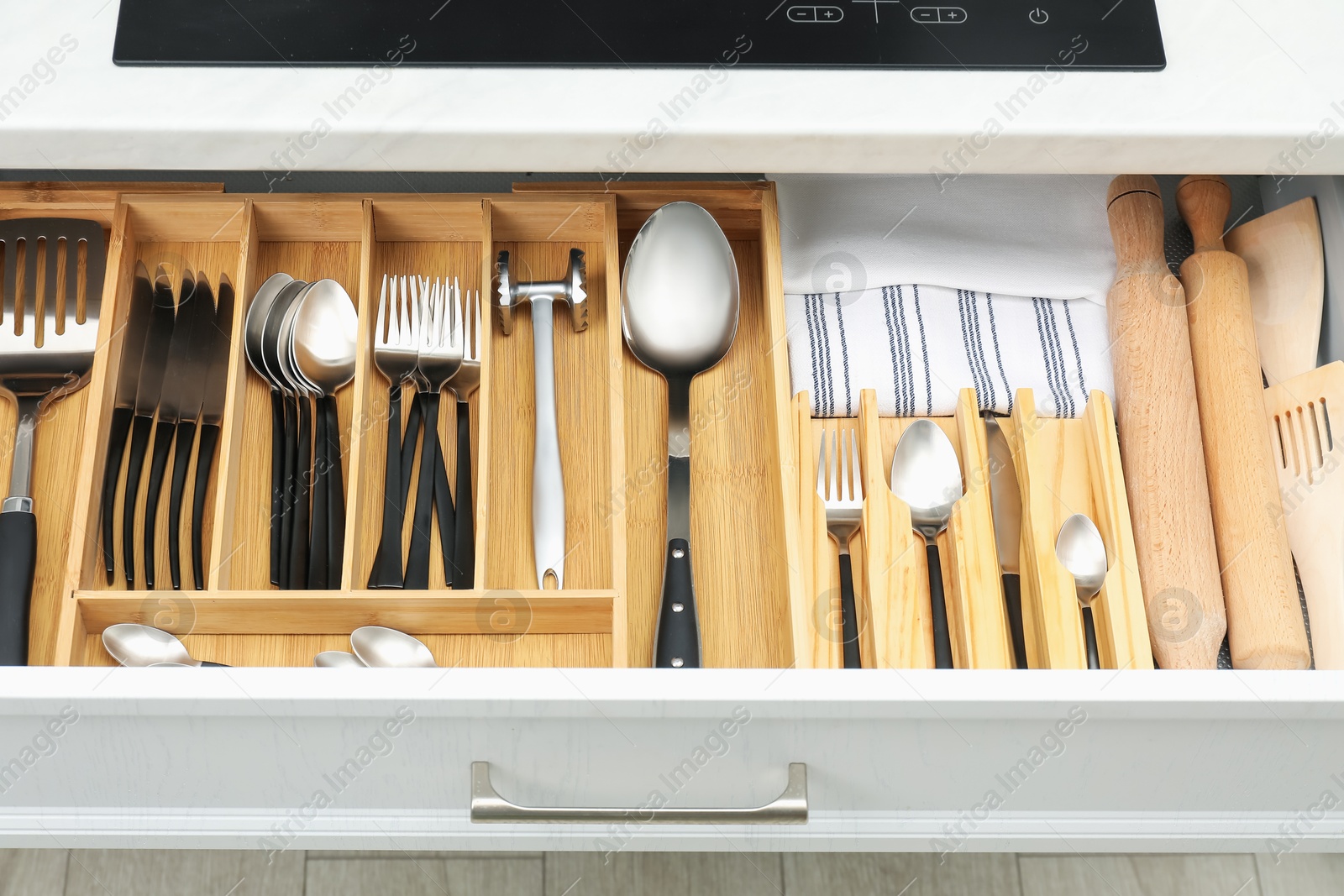 Photo of Box with cutlery in drawer, closeup. Kitchen utensils storage