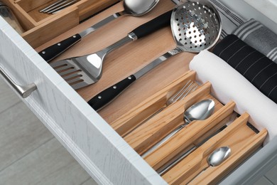 Photo of Box with cutlery in drawer, closeup. Kitchen utensils storage