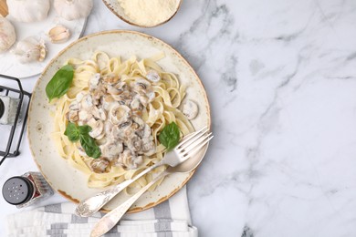 Photo of Delicious pasta with mushrooms served on white marble table, flat lay. Space for text