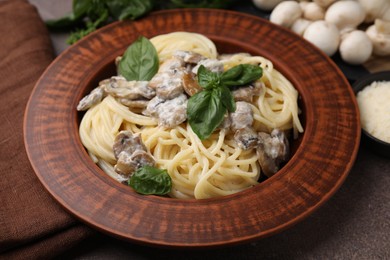 Photo of Delicious pasta with mushrooms and basil on table, closeup