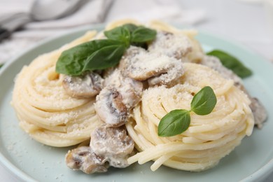 Photo of Delicious pasta with mushrooms and basil on table, closeup