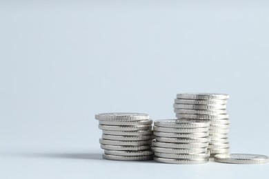 Photo of Salary concept. Stacked coins on light grey background, closeup. Space for text