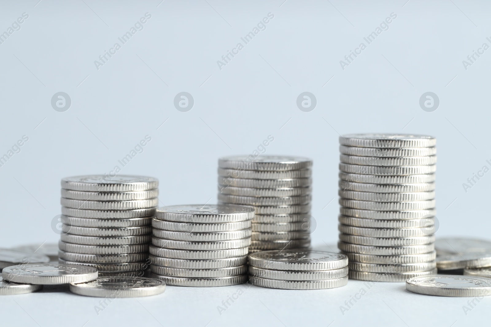 Photo of Salary concept. Stacked coins on light grey background, closeup. Space for text