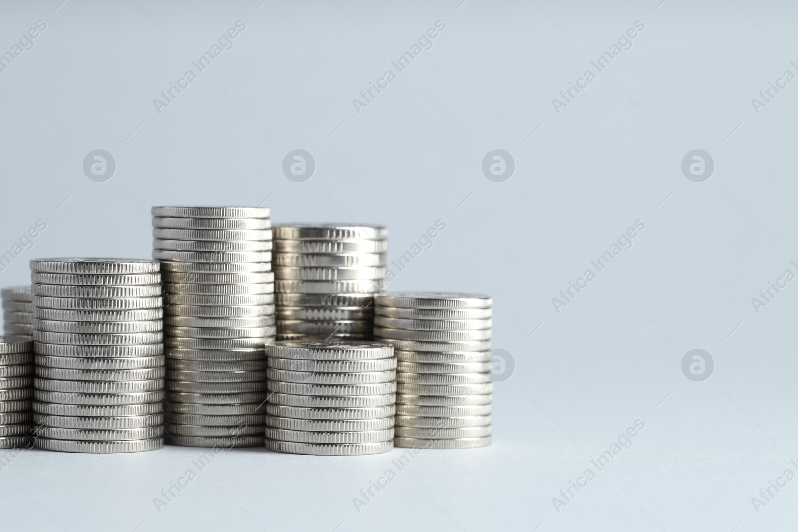 Photo of Salary concept. Stacked coins on light grey background