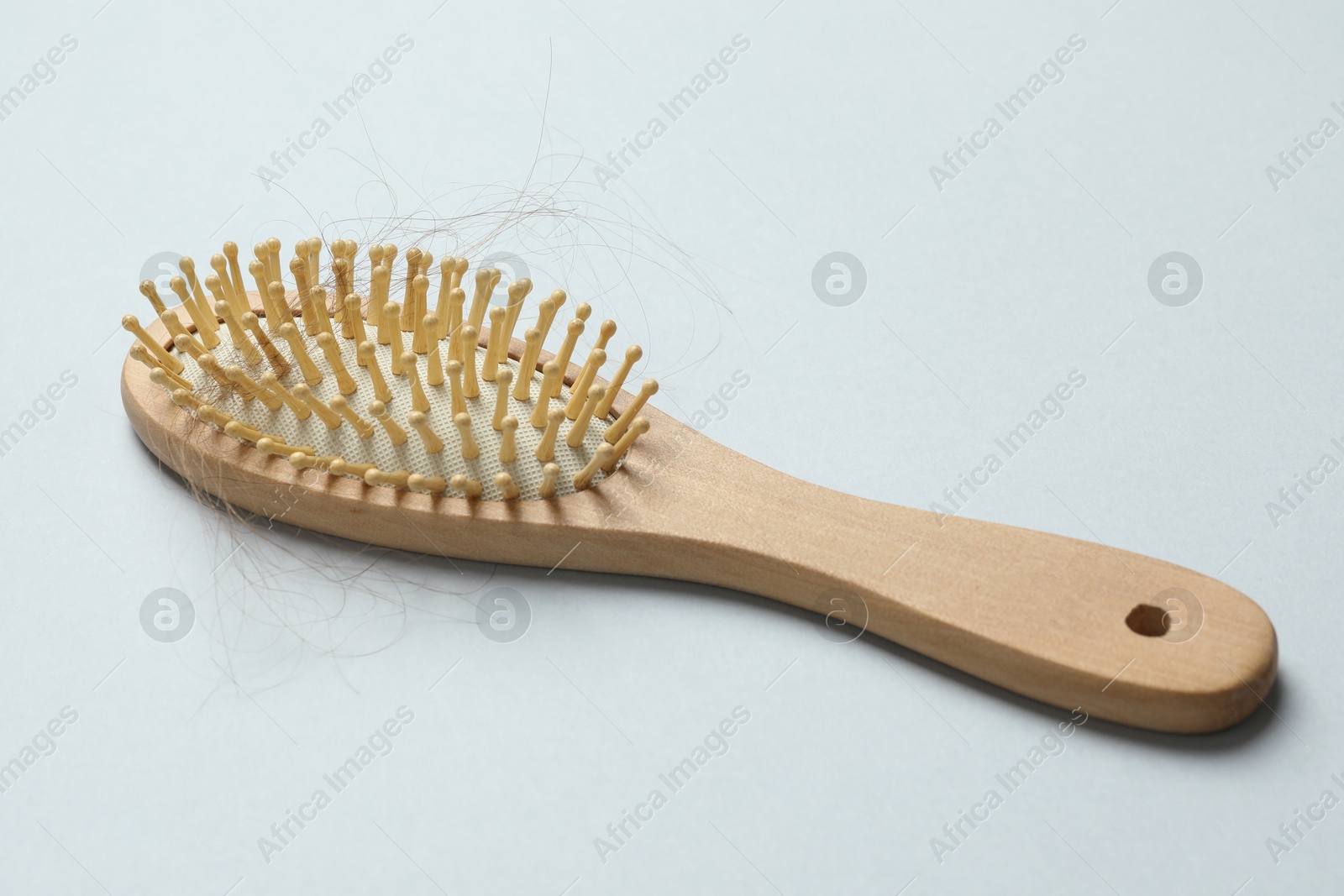 Photo of One brush with lost hair on grey background. Alopecia problem