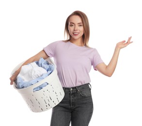 Photo of Happy young housewife with basket full of laundry on white background