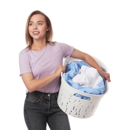 Happy young housewife with basket full of laundry on white background