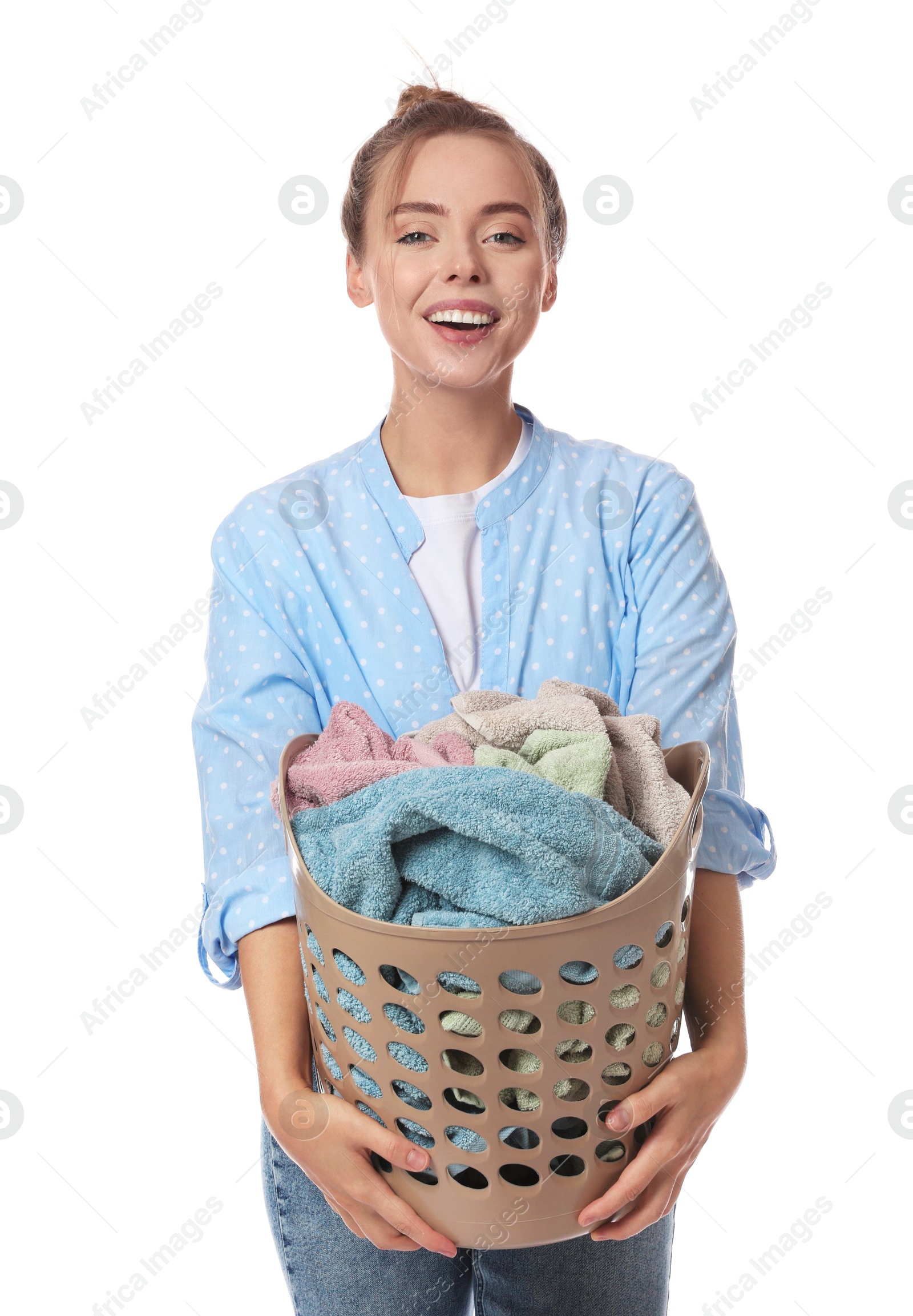 Photo of Happy young housewife with basket full of laundry on white background