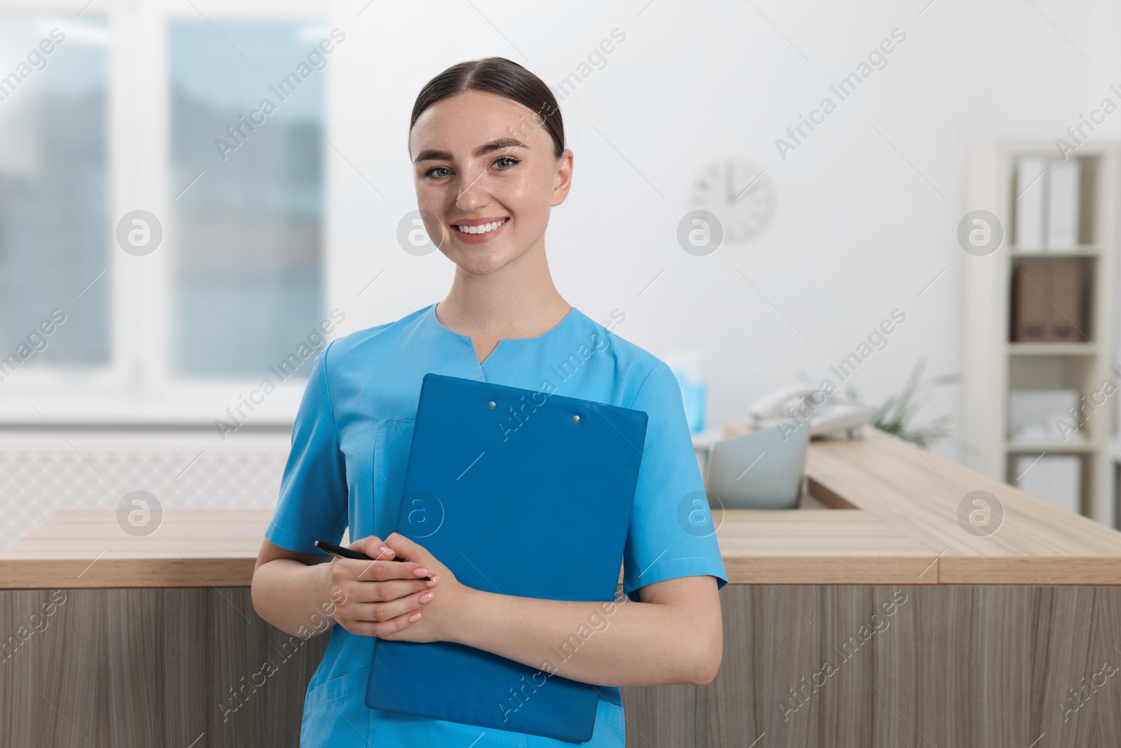 Photo of Professional receptionist with clipboard working in hospital