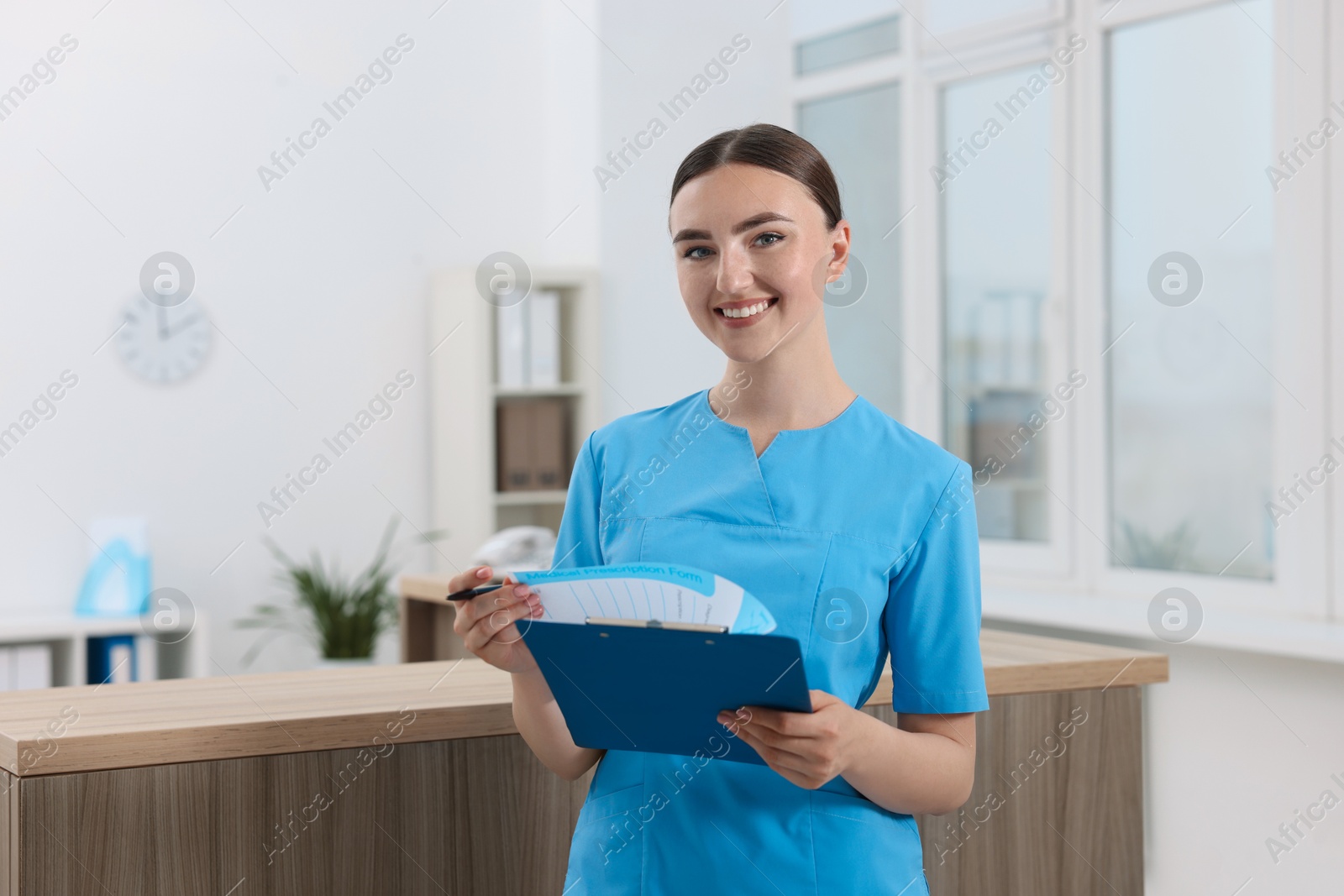 Photo of Professional receptionist with clipboard working in hospital