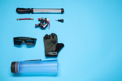 Photo of Flat lay composition with cycling accessories on light blue background, space for text