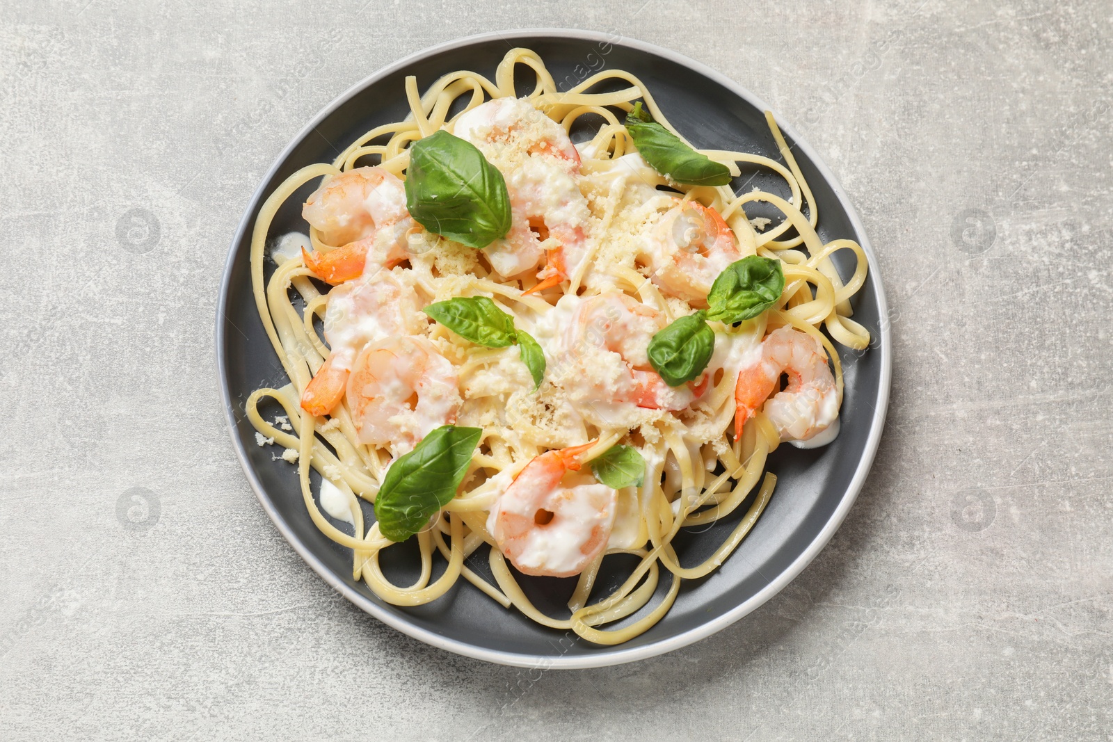 Photo of Tasty pasta with shrimps on light grey table, top view