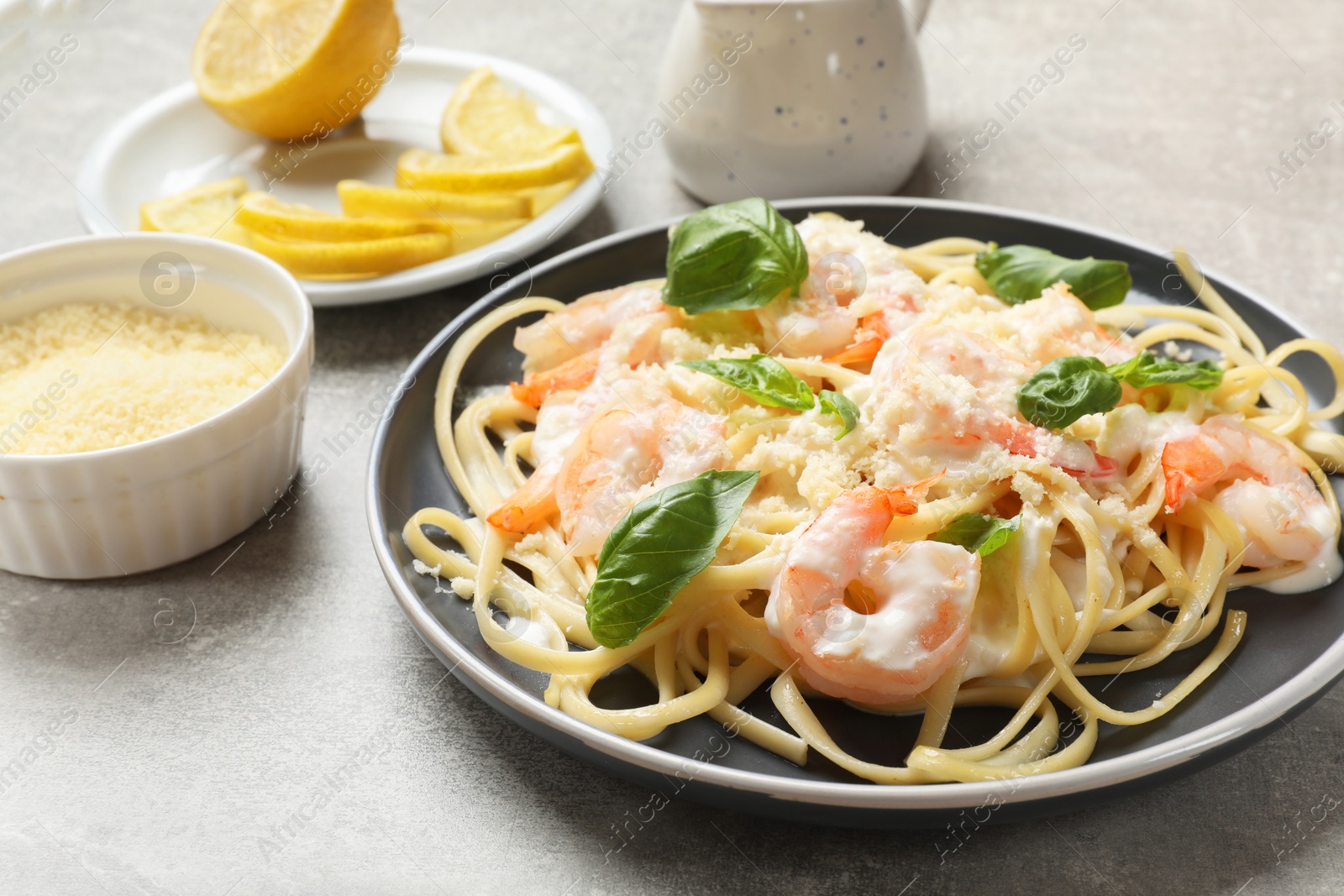 Photo of Tasty pasta with shrimps on light grey table, closeup