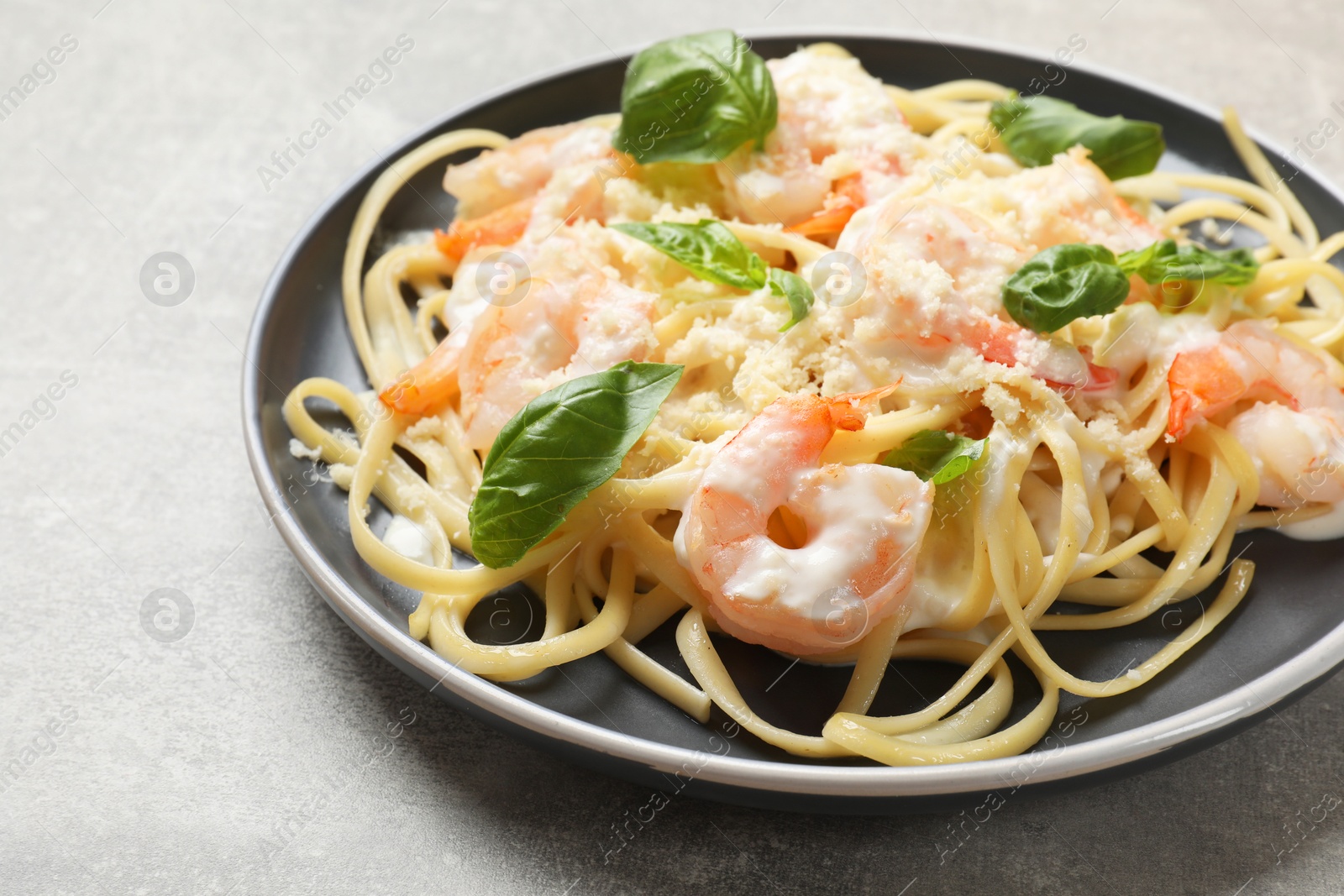 Photo of Tasty pasta with shrimps on light grey table, closeup