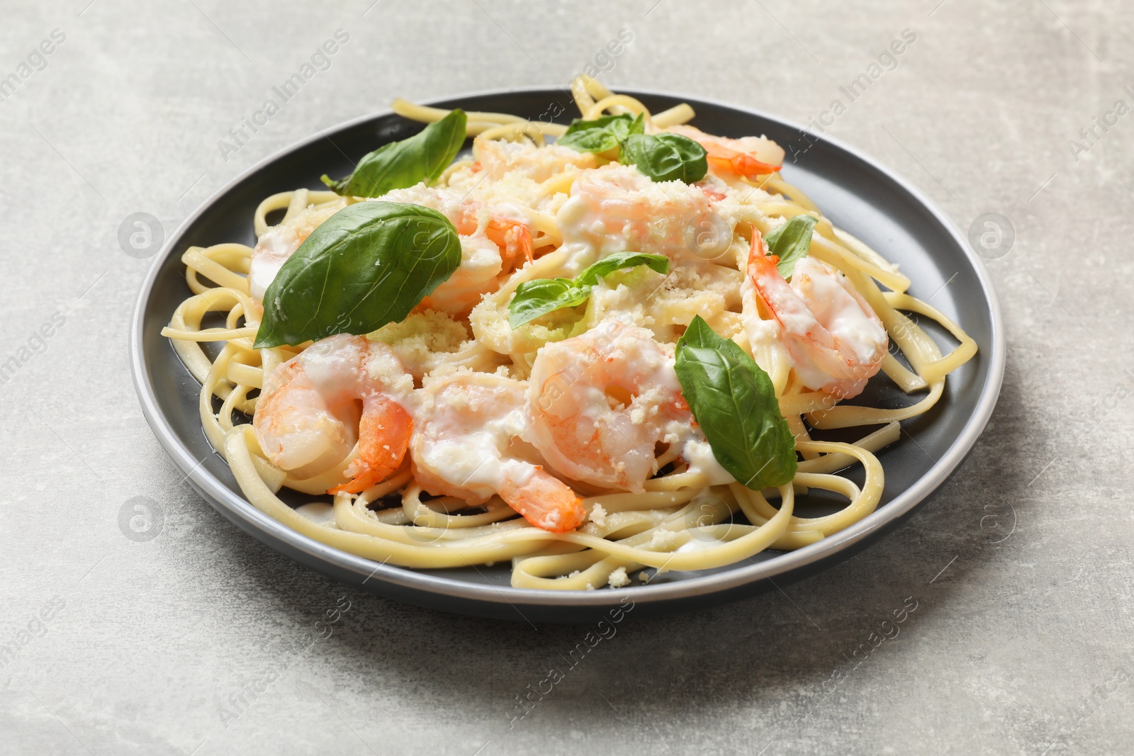 Photo of Tasty pasta with shrimps on light grey table, closeup