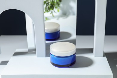 Photo of Stylish presentation of face cream against blue background