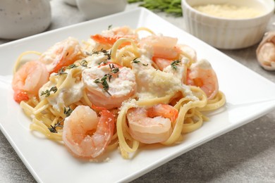 Delicious pasta with shrimps served on light table, closeup