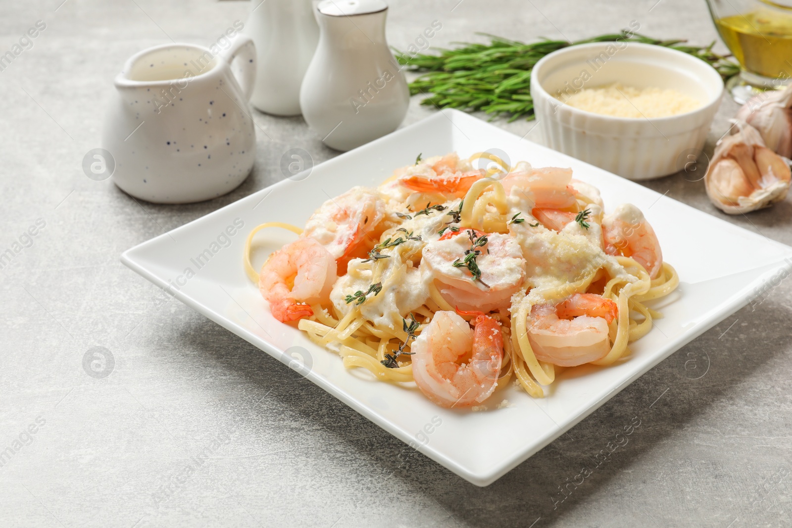 Photo of Delicious pasta with shrimps served on light table