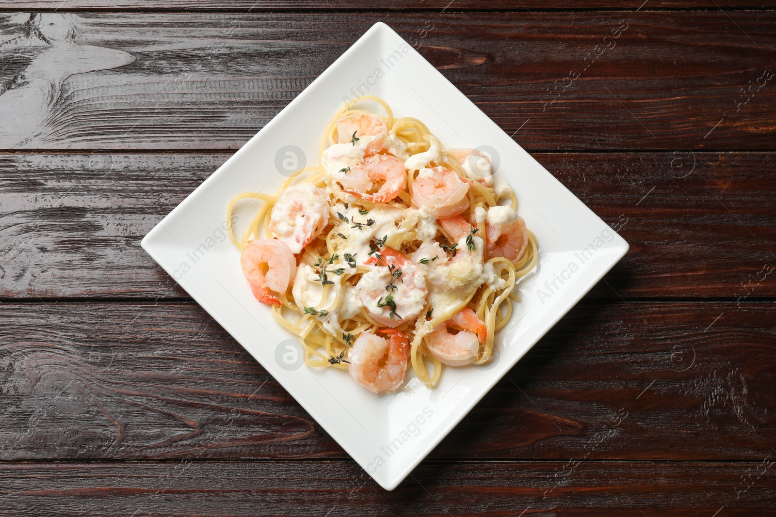 Photo of Delicious pasta with shrimps on wooden table, top view