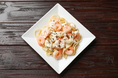 Photo of Delicious pasta with shrimps on wooden table, top view