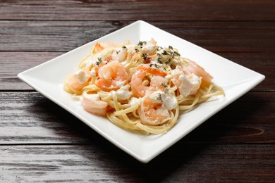 Delicious pasta with shrimps on wooden table