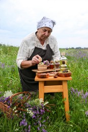 Photo of Senior woman with mortar and pestle making tincture outdoors