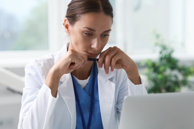 Nurse in medical uniform with pen indoors