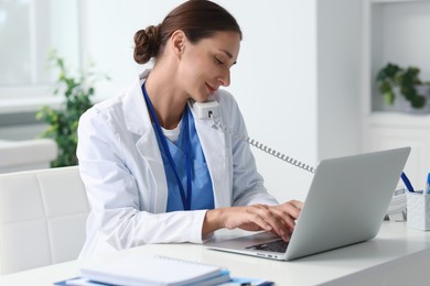 Nurse consulting patient by phone at white table in clinic