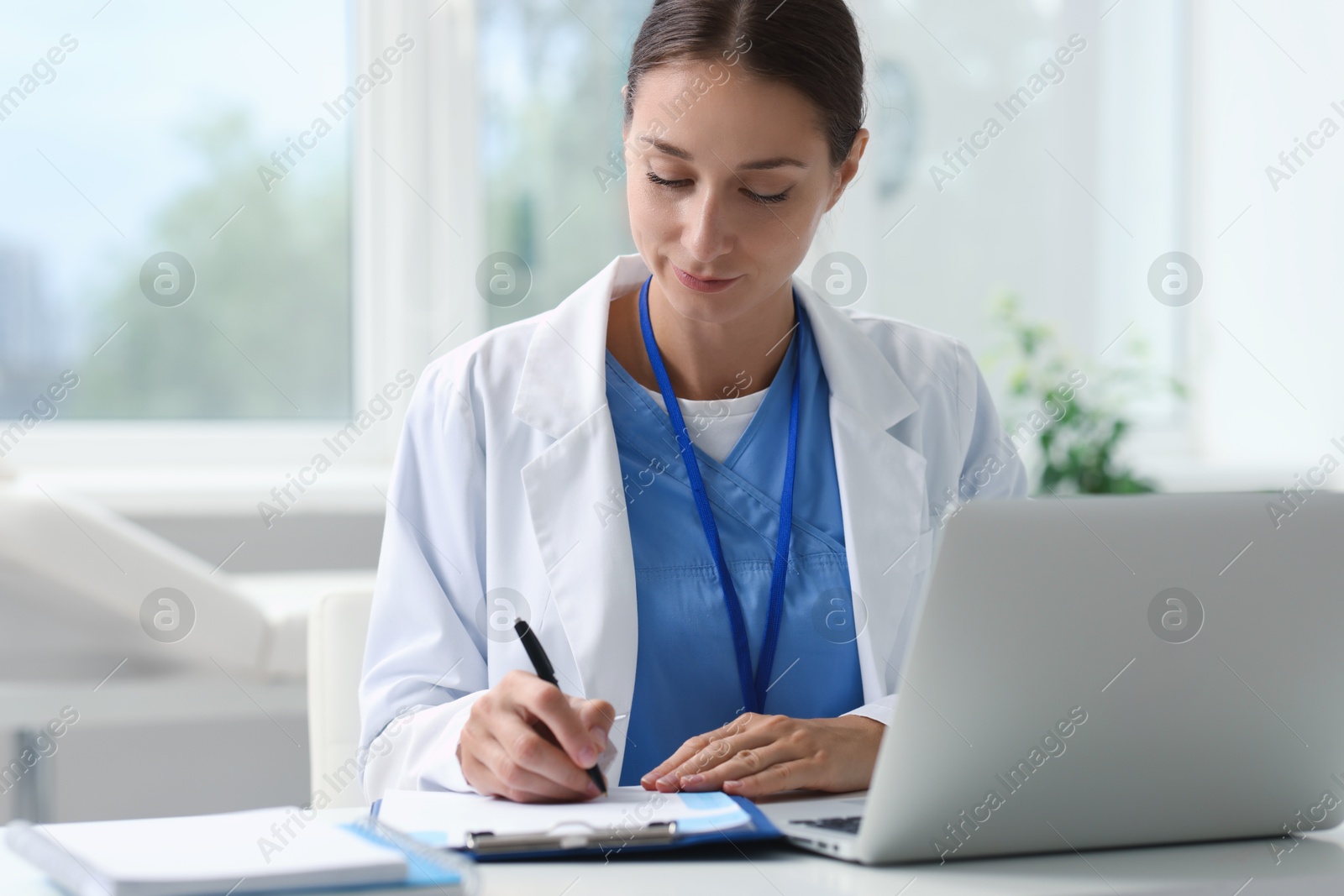 Photo of Nurse taking notes at table in clinic