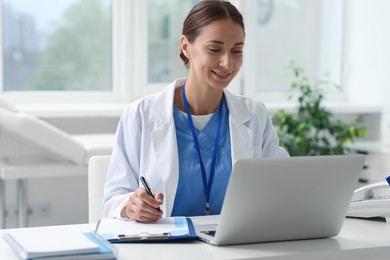 Nurse taking notes at white table in clinic