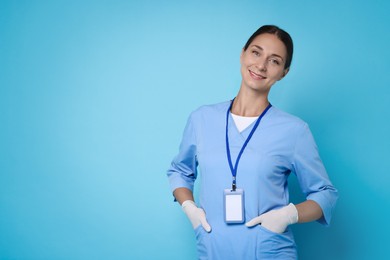 Photo of Nurse in medical uniform on light blue background, space for text