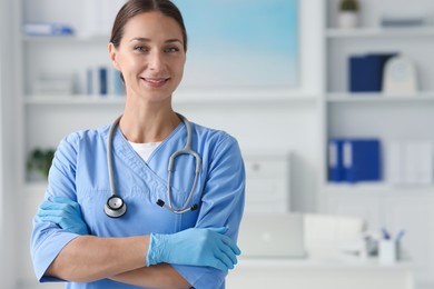 Nurse in medical uniform with stethoscope indoors, space for text