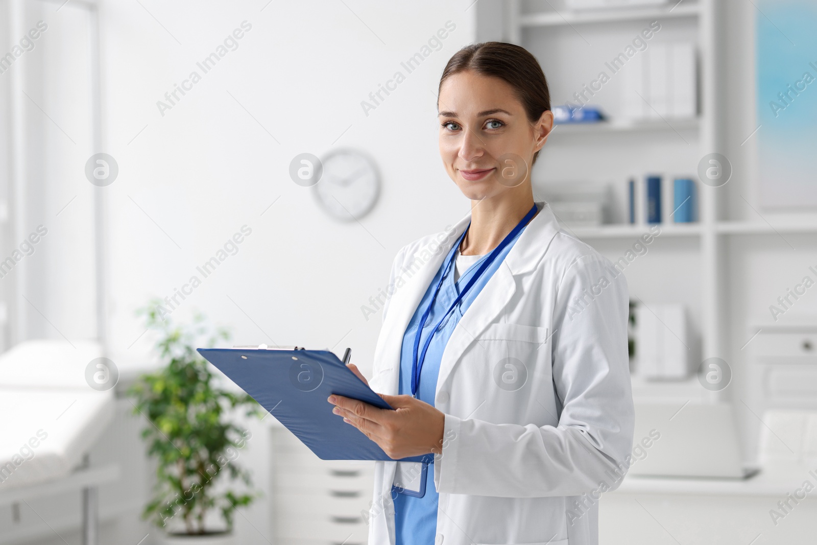 Photo of Nurse in medical uniform with clipboard indoors