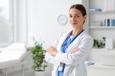 Nurse with crossed arms in clinic, space for text