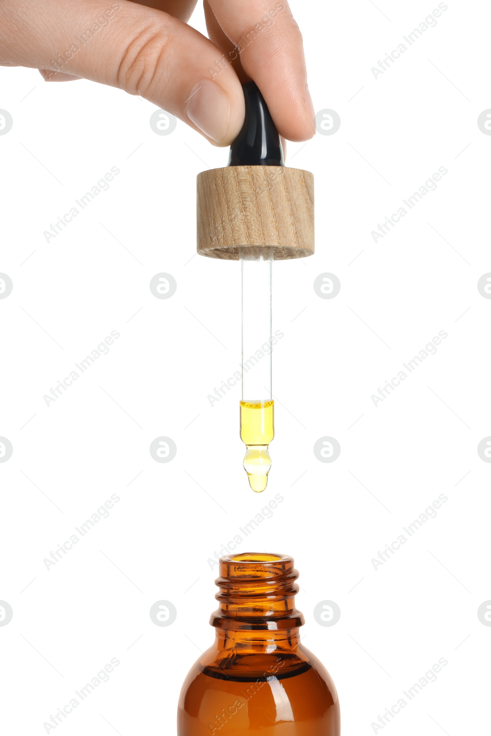 Photo of Woman dripping tincture from pipette into bottle on white background, closeup